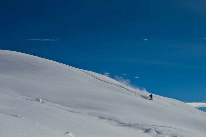 uno sciatore sta scendendo da un pendio innevato