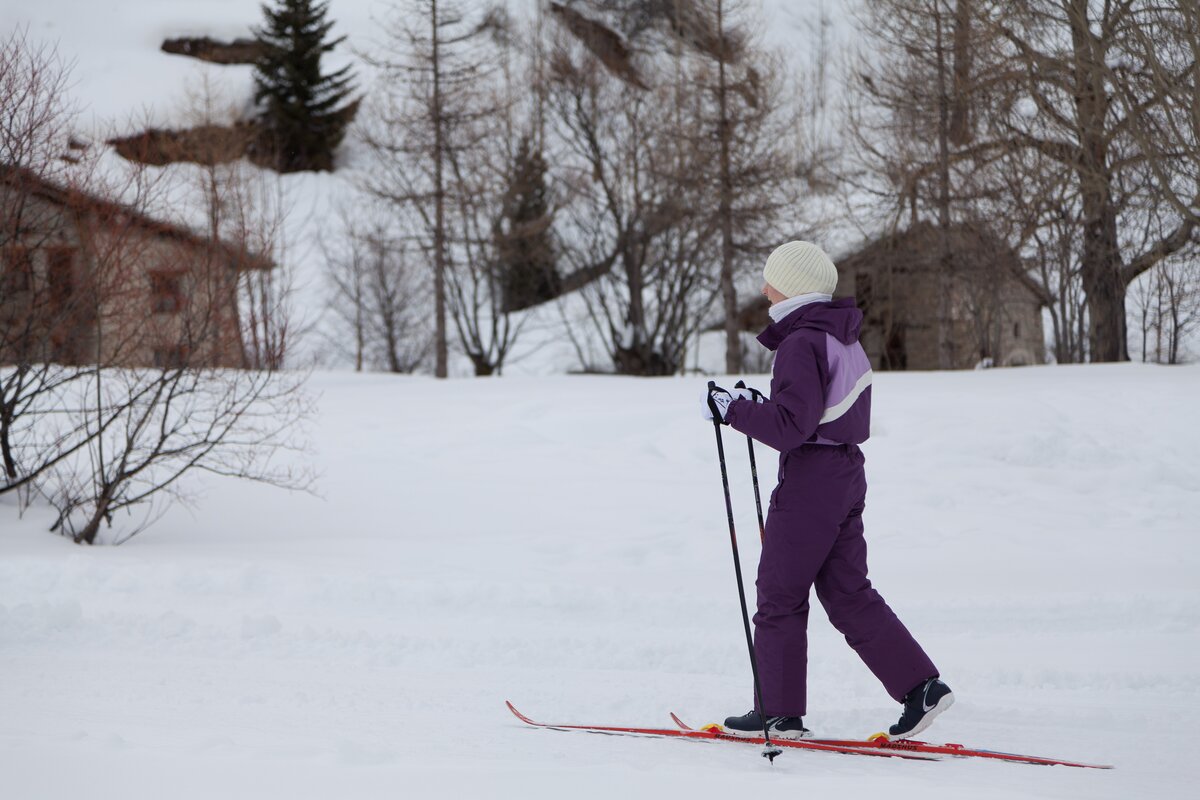 uno sciatore vestito con una tuta viola immerso nella neve bianca