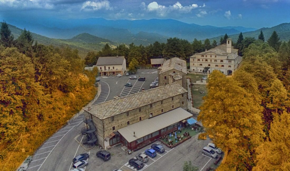 il santuario, in alto a destra nella foto, visto dalla collina di fronte. panorama sulla valle e sul piazzale antistante al santuario, con edifici e parcheggi