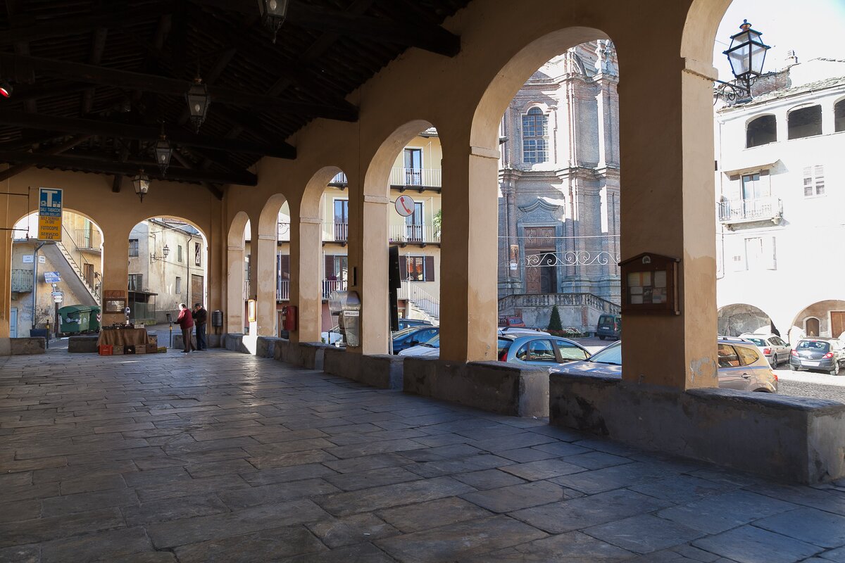 in primo piano l'ala porticata del paese, dietro alla quale si intravede la parrocchiale