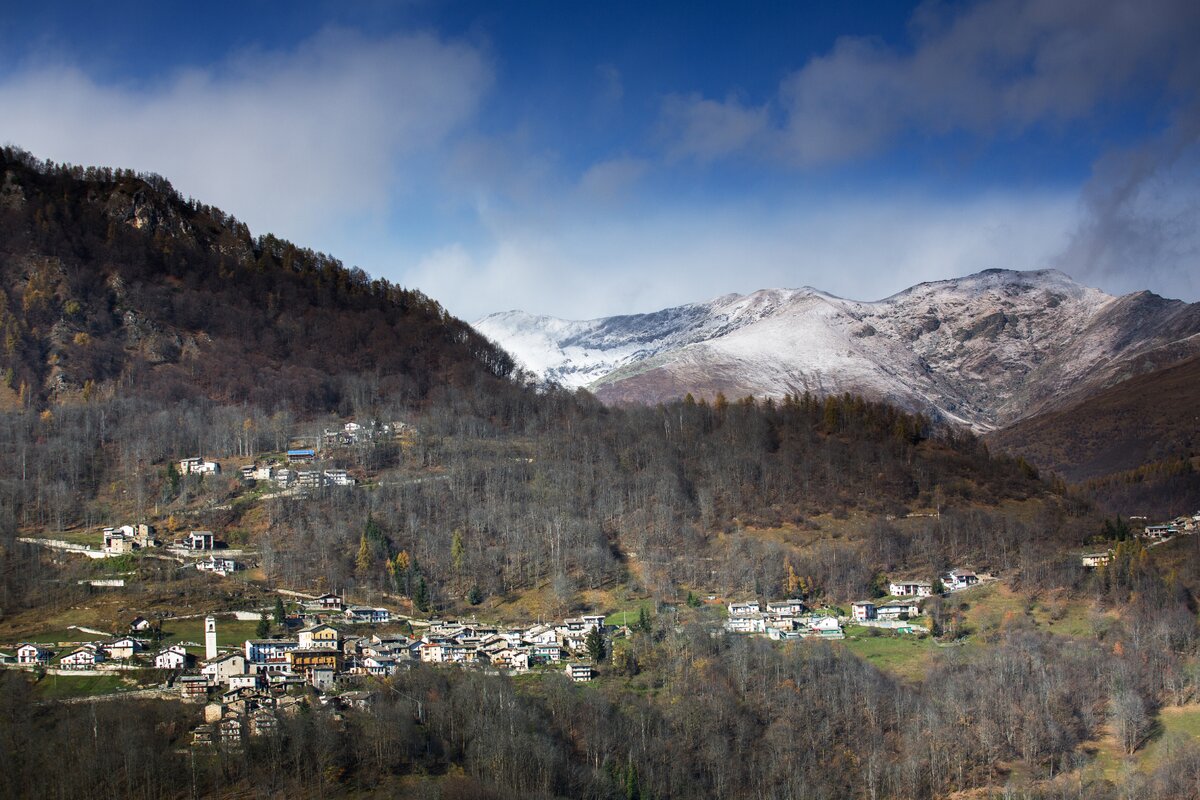 Panorama autunnale su alcune borgate di Oncino: sullo sfondo si vedono i rilievi imbiancati dalla neve