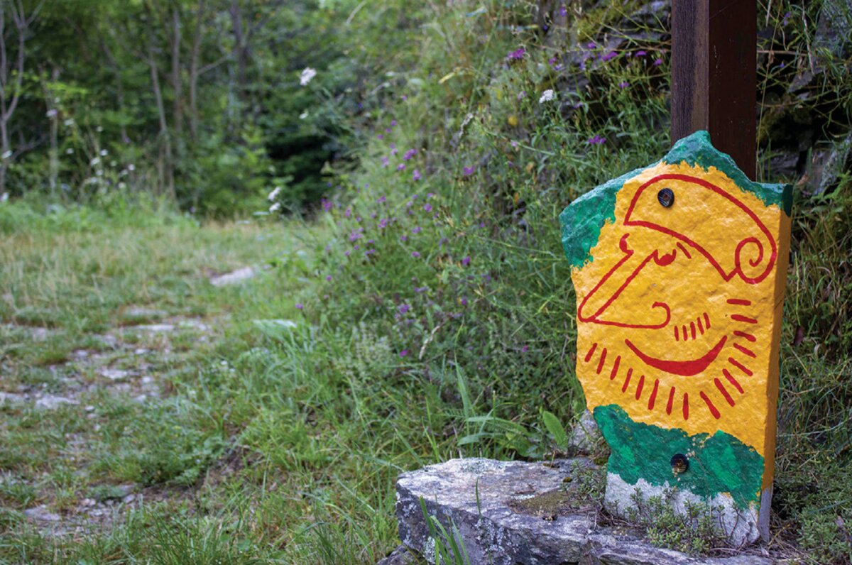 un tratto del sentiero, con una caratteristica pietra segnavia dipinta con le fattezze del volto  di un folletto dei boschi