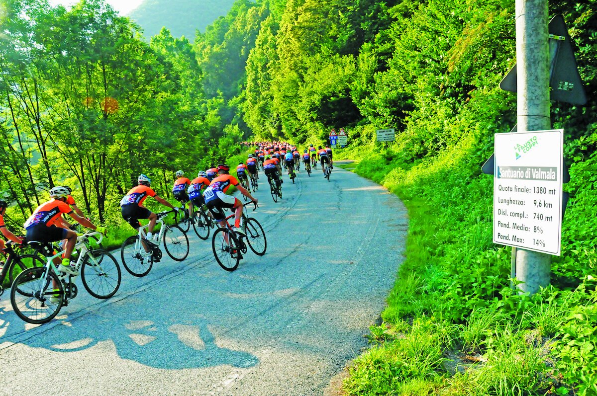 gruppo di ciclisti su fondo stradale, in curva