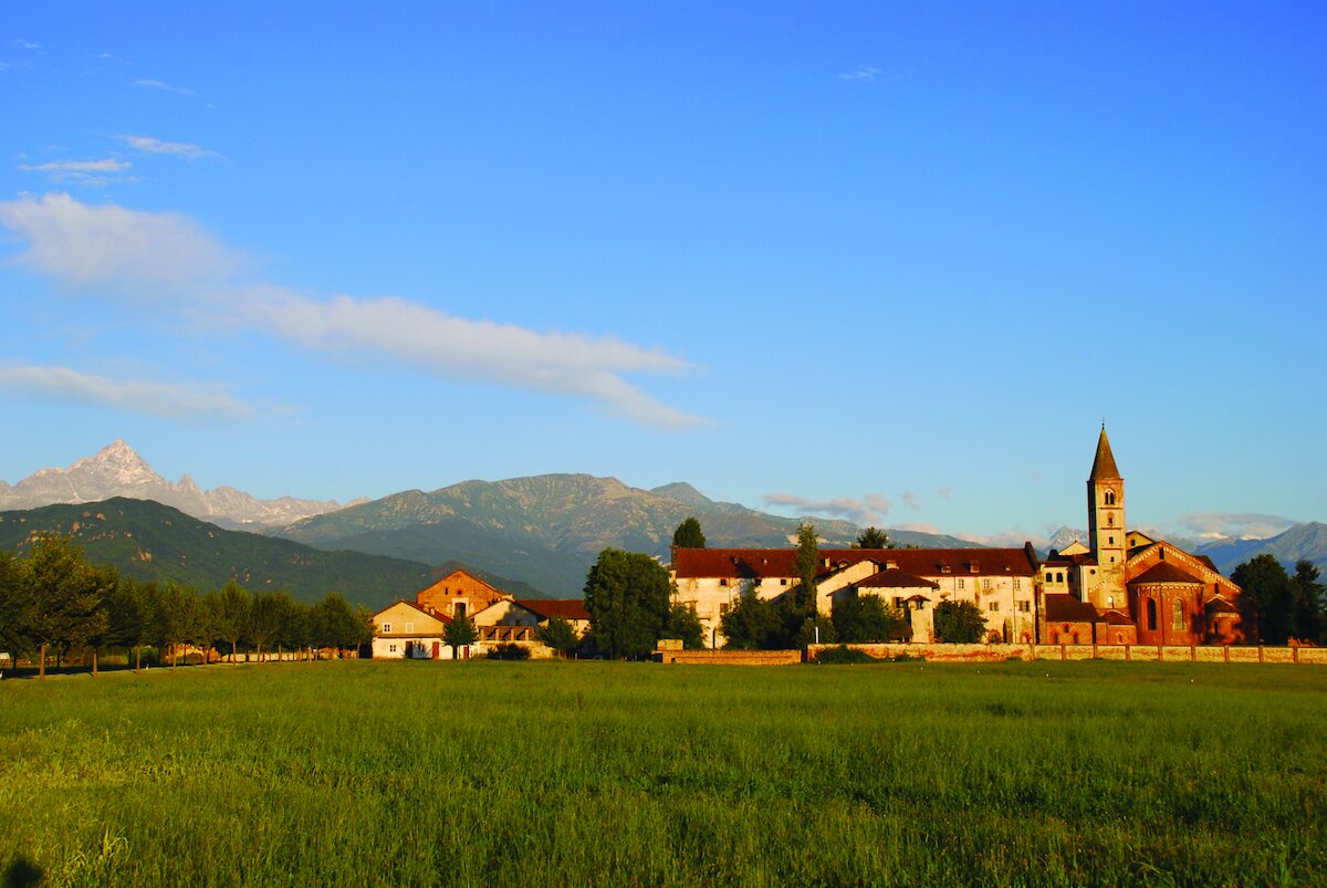 in foto l'abbazia di Staffarda e sullo sfondo in alto a sinistra il Monviso