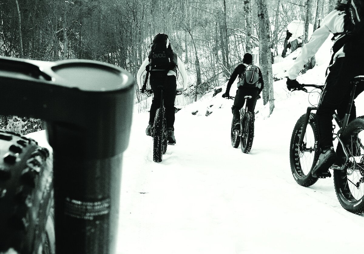 foto in bianco e nero di biciclette MTB su percorso innevato.